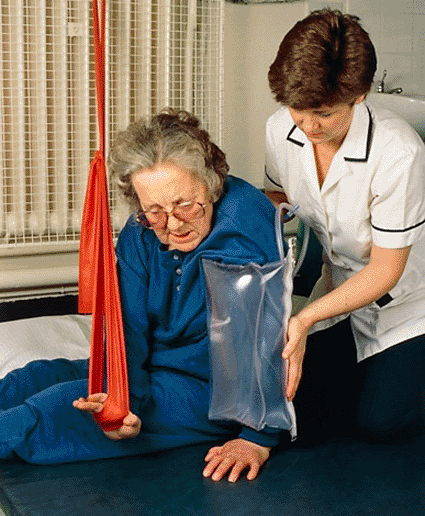 Image: Stroke patient with left-side paralysis (hemiplegia), wearing an inflatable splint to support her disabled arm so she can support her weight on it and aid her recovery (Photo courtesy of Simon Fraser, Hexham General).